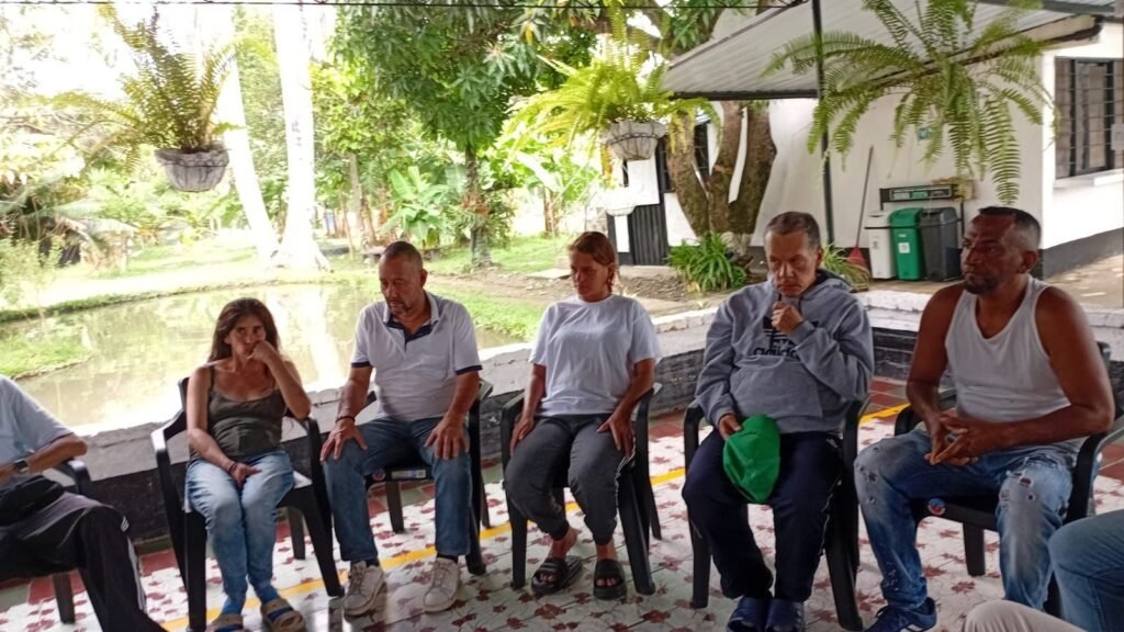 Deltagare sitter i samtal utomhus under en aktivitet med Fundación Lagom i Colombia