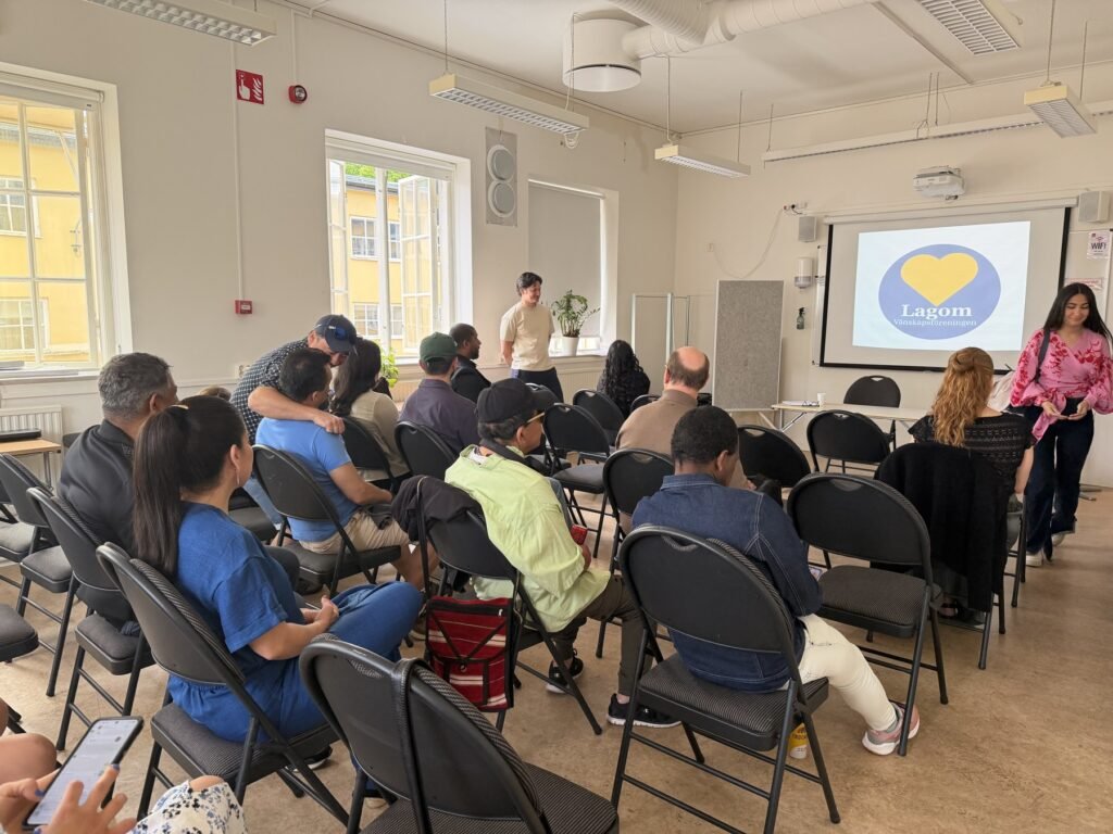 Deltagare sitter tillsammans under en presentation vid en Lagomträff i Sverige
