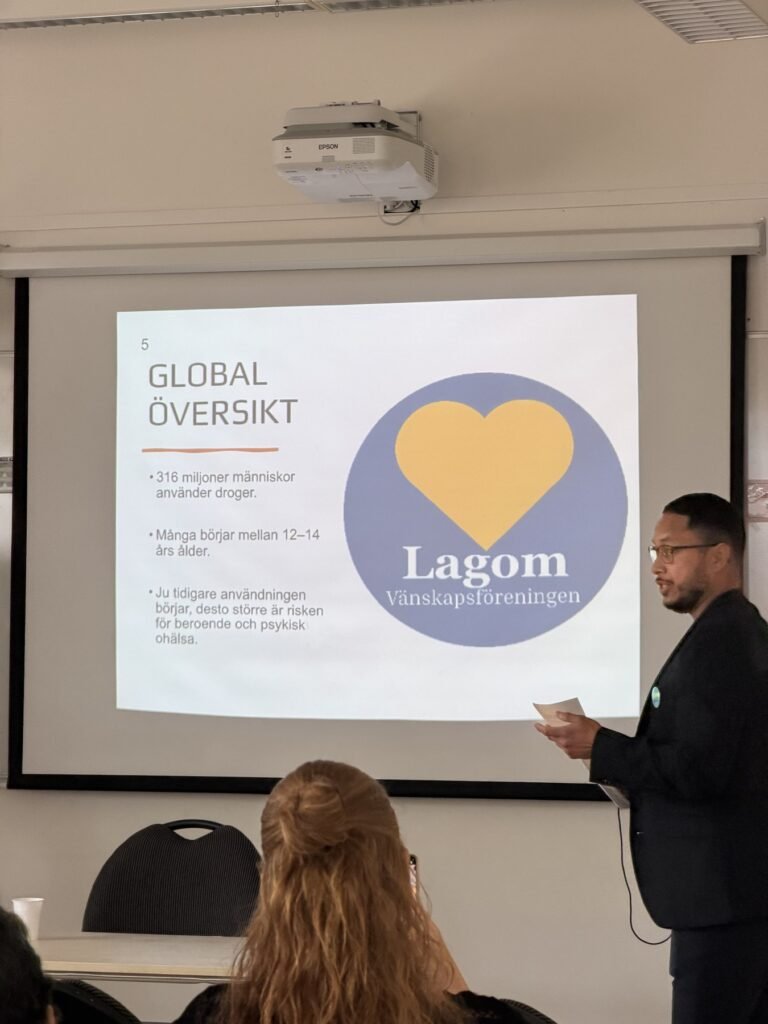 En talare presenterar Lagoms arbete framför föreningens logotyp i Sverige