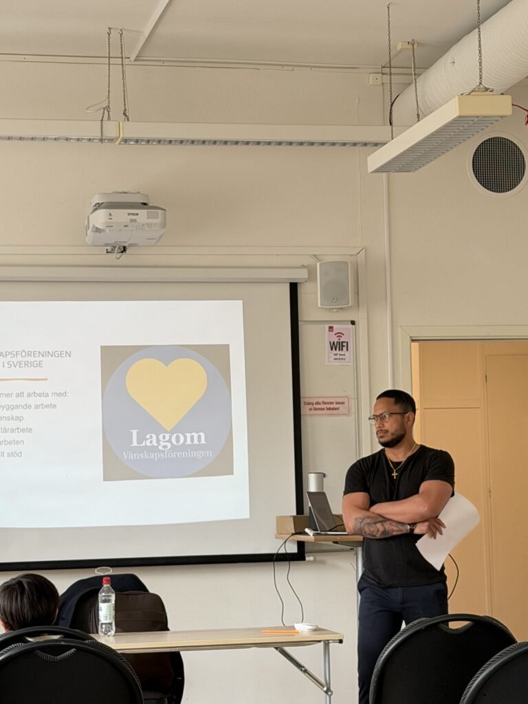 En talare presenterar inför deltagare vid en Lagomträff i Sverige