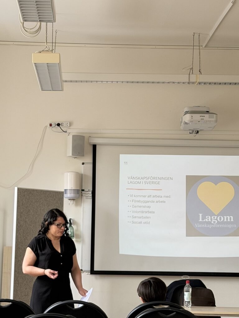 En talare står framför en presentation med Lagoms logotyp i Sverige